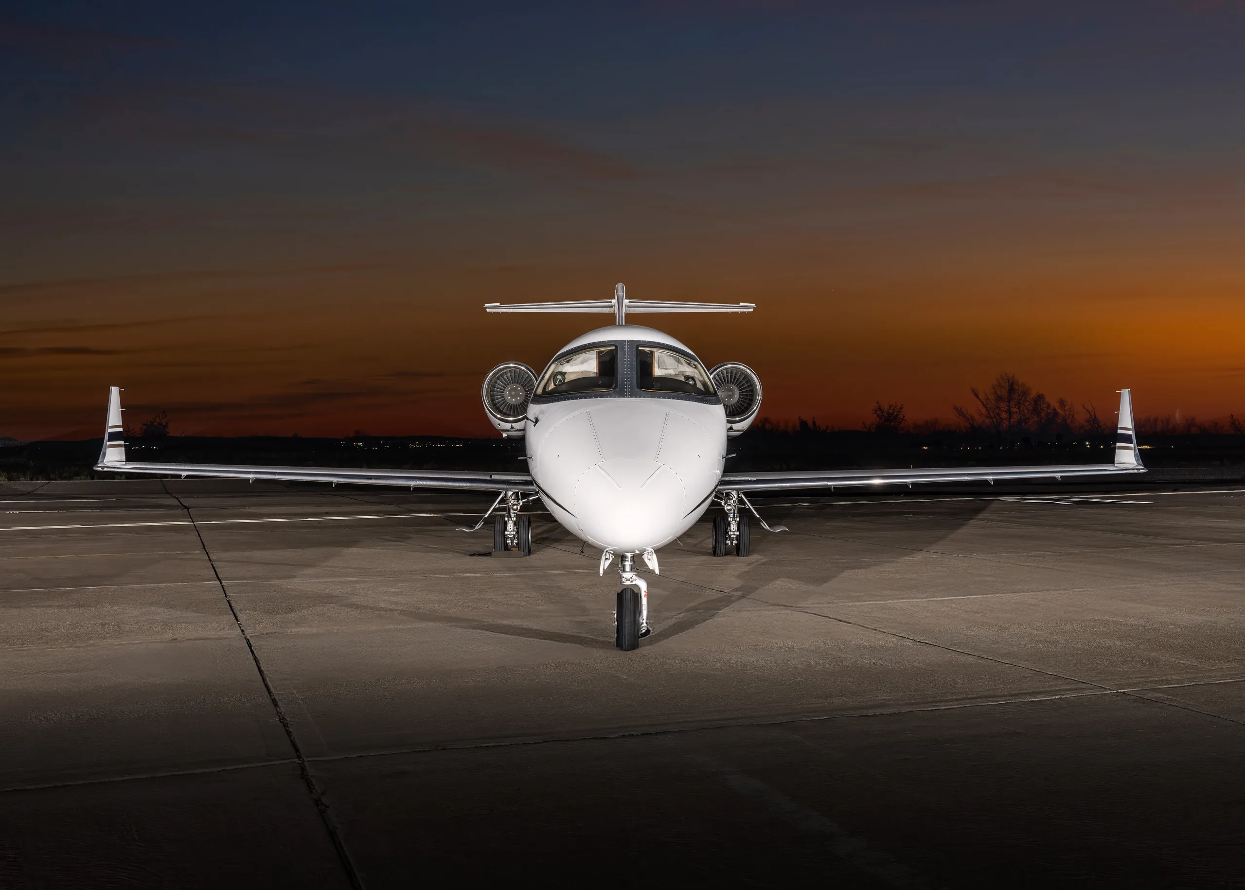 Front view of a white Learjet 60, registration N623FC, parked on an airfield at dusk.