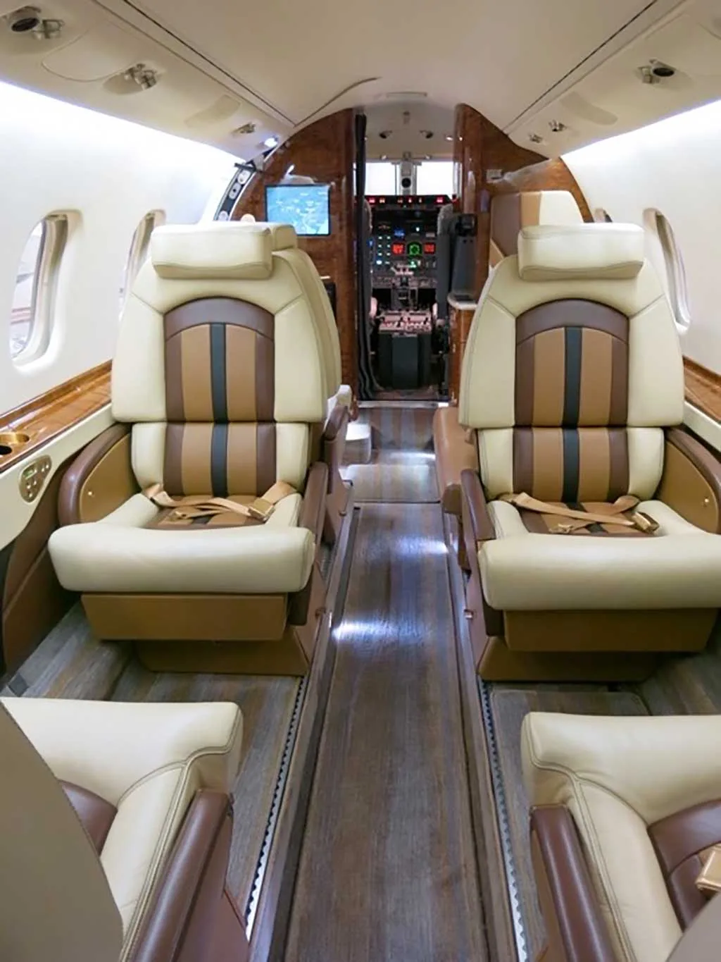View of the aircraft cabin interior with two-tone beige and brown seats, looking towards the cockpit.