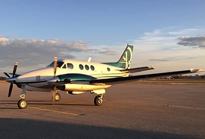 A Beechcraft King Air on the tarmac at sunset.