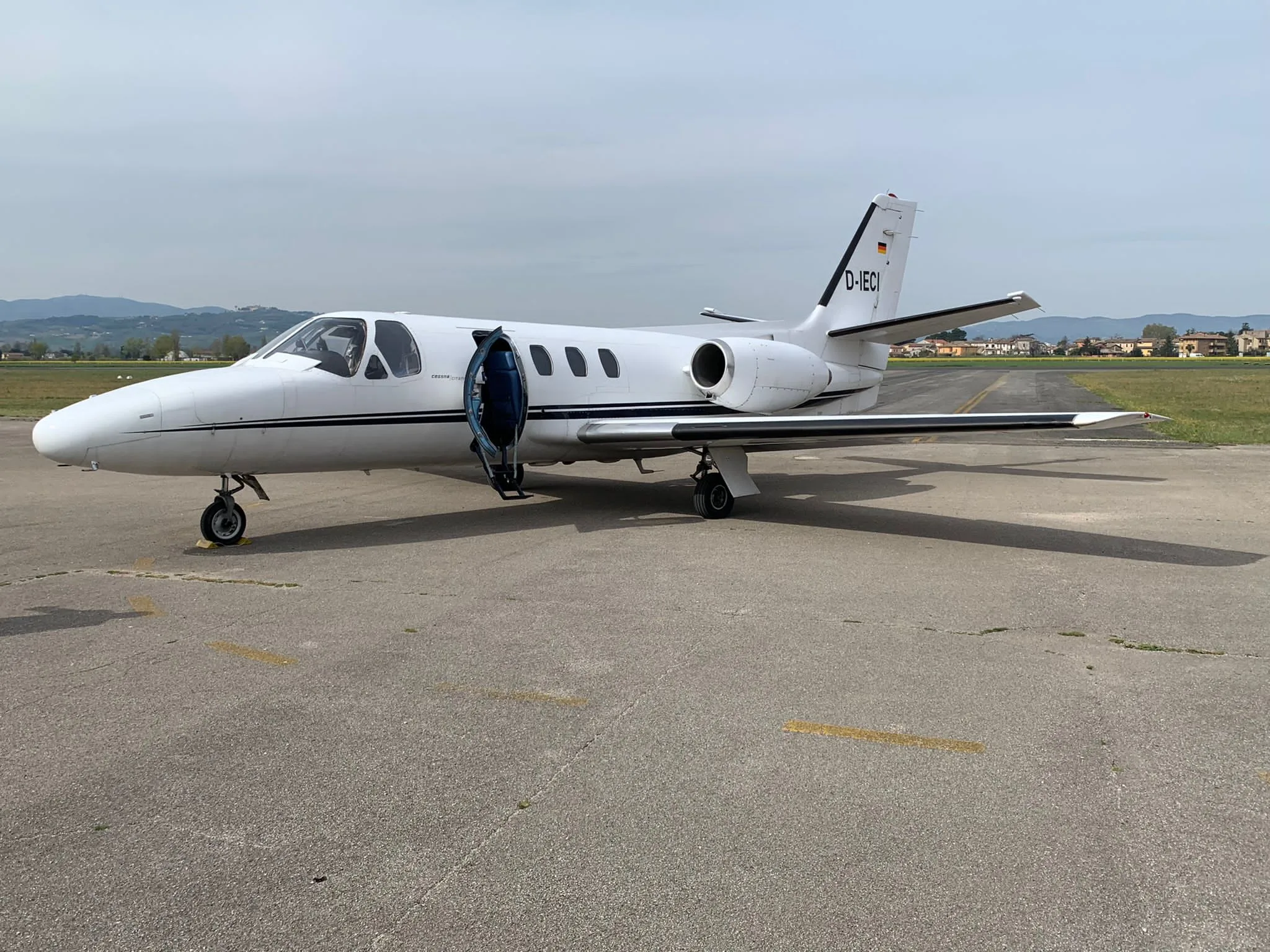 A Cessna Citation Mustang aircraft, registration D-IECI, parked on the tarmac with the door open.