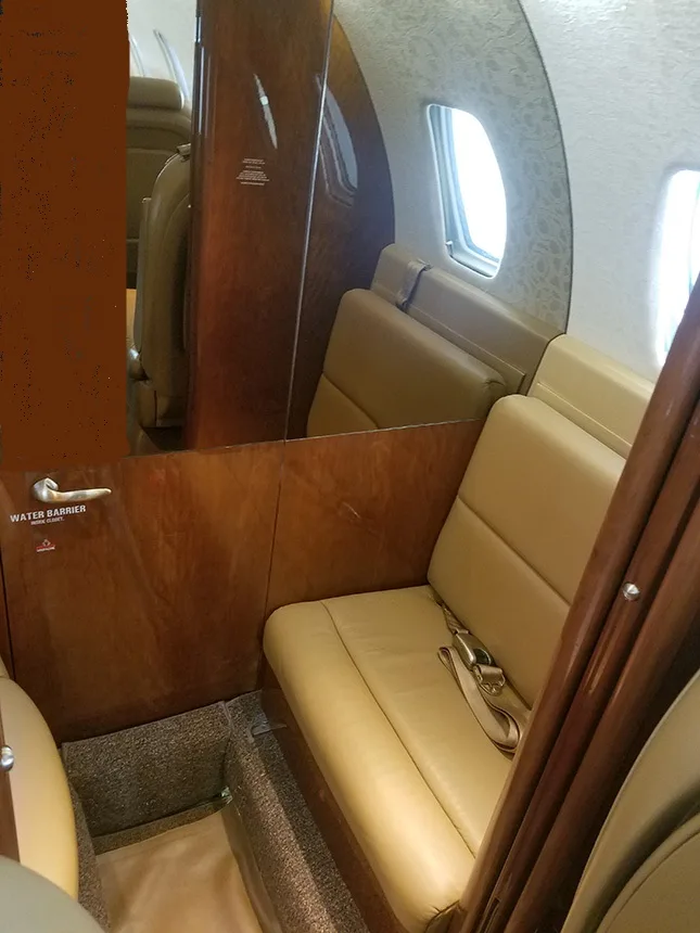Interior view of the aircraft showing the cabin seats and a water barrier sign.