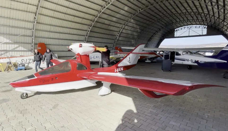 Osprey 2 aircraft with red and white paint scheme in a hangar.