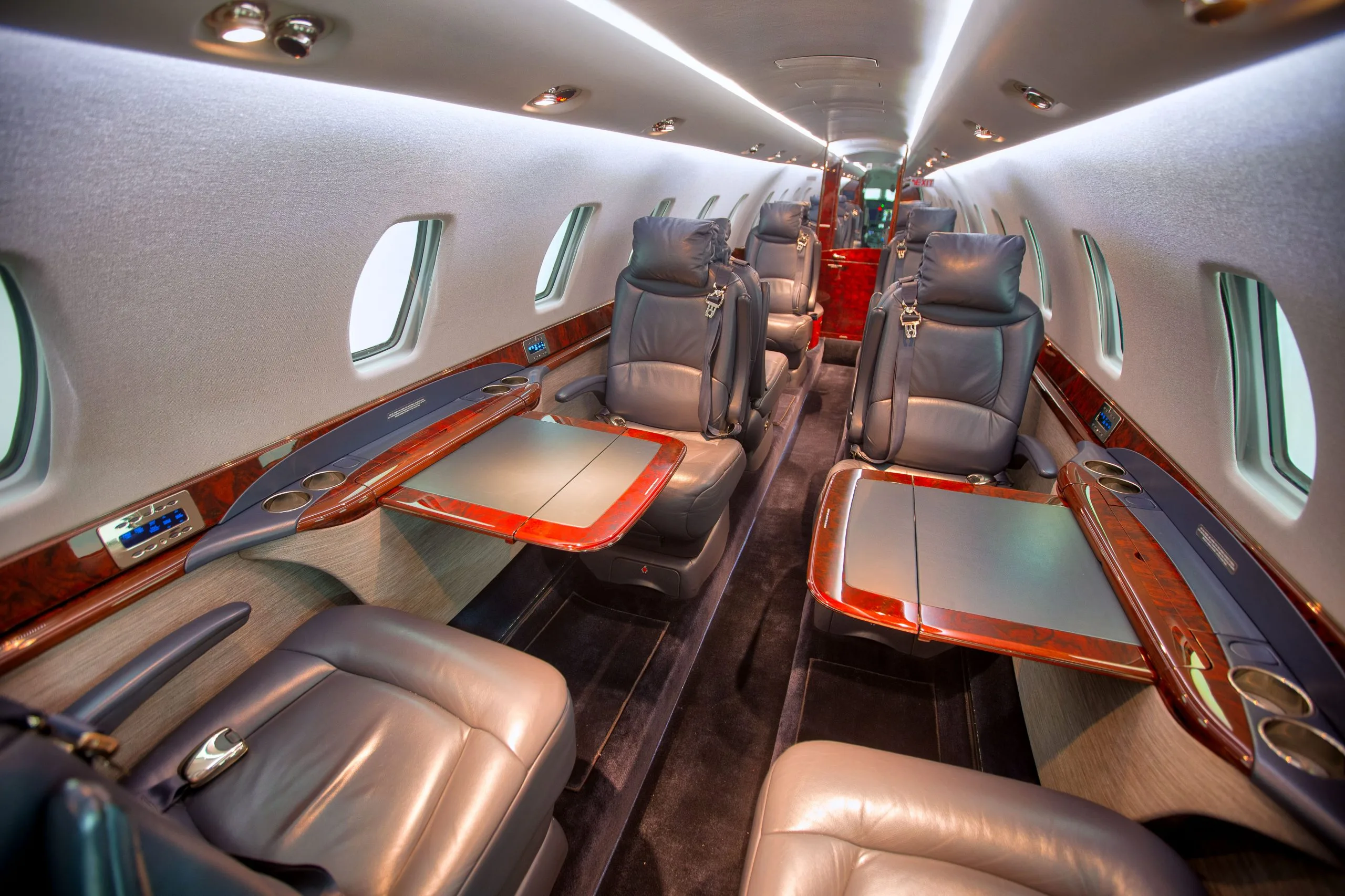 A view of the aircraft cabin with leather seats and wood trim.