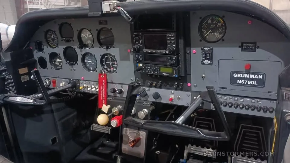 The cockpit of a Grumman aircraft, showing the instrument panel and controls.