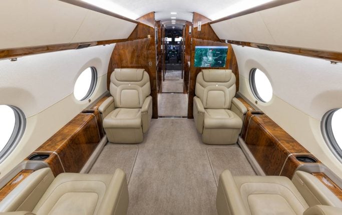 Aircraft cabin interior with a sofa and a television.