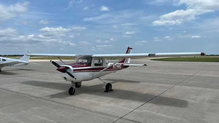 A white and red Cessna 172 Skyhawk sits on the tarmac.