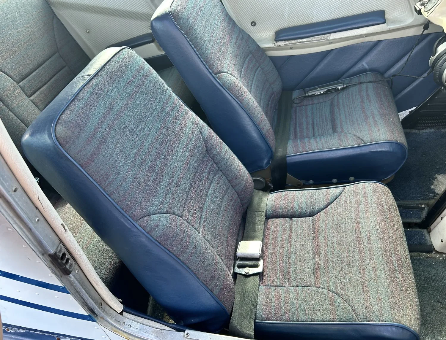 The interior of the aircraft, showing the blue and patterned seats.