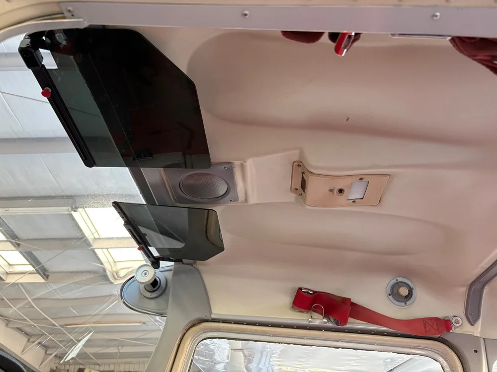 The cream-colored ceiling of the aircraft cabin with sun visors and overhead vents.