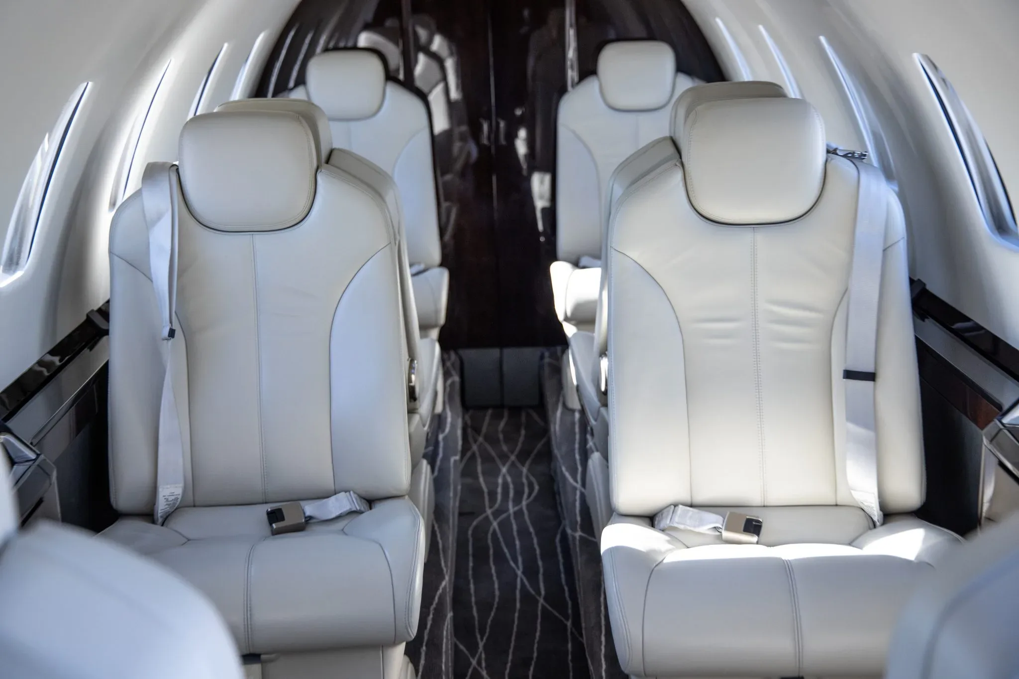 A close-up view of the light-colored leather seats in the aircraft's passenger cabin.