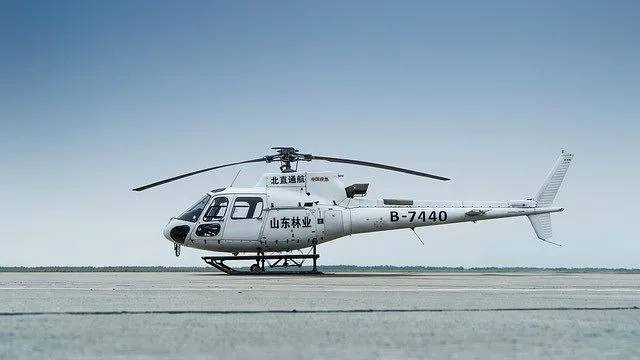 A white single-engine helicopter, registration B-7440, with Chinese characters on its side, sits on an asphalt runway.