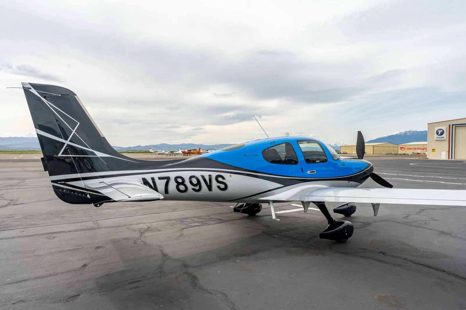 Side view of a black, blue, and silver single-engine aircraft with registration N789VS on an airfield.