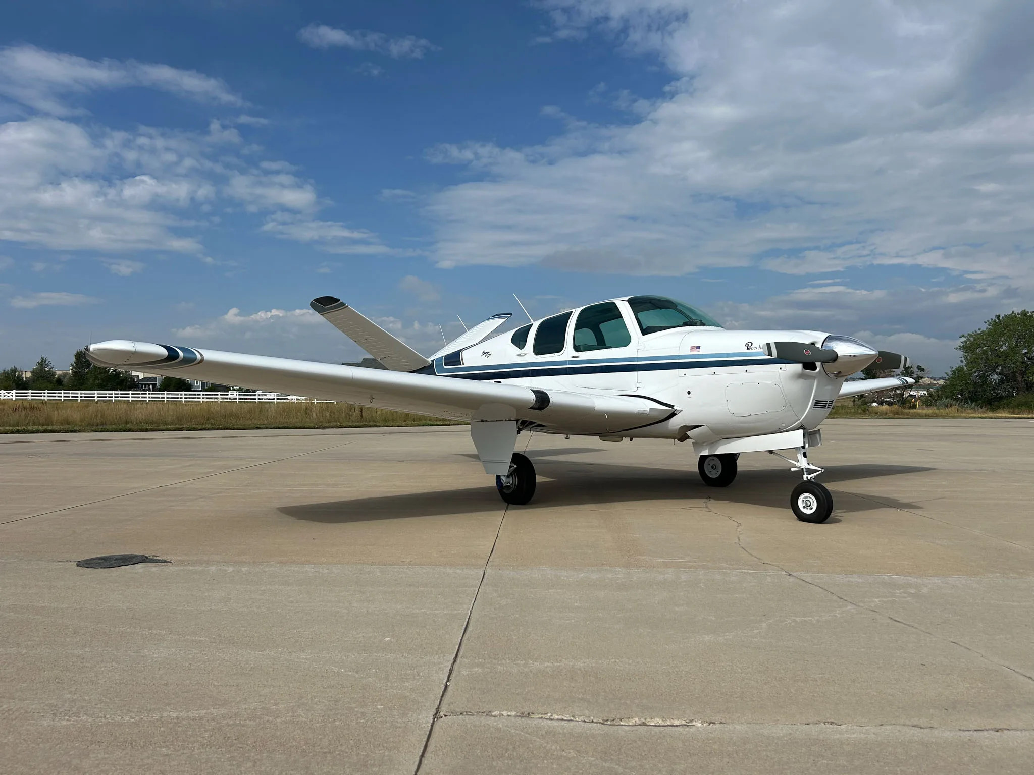 Beechcraft Baron on the tarmac with white and blue paint scheme.