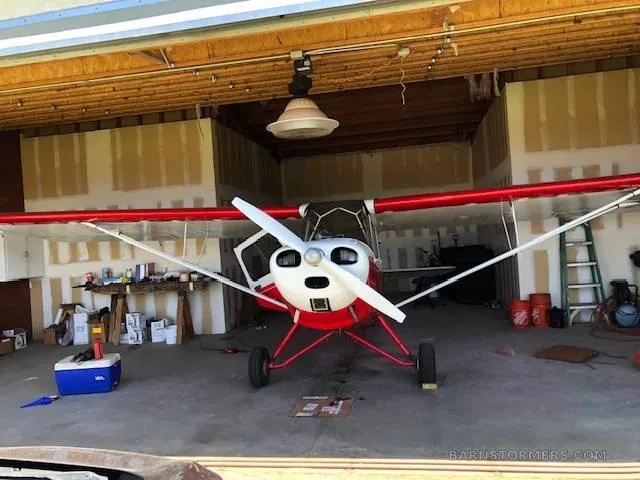 The cockpit of a light aircraft showing the instrument panel with various gauges and a single seat.