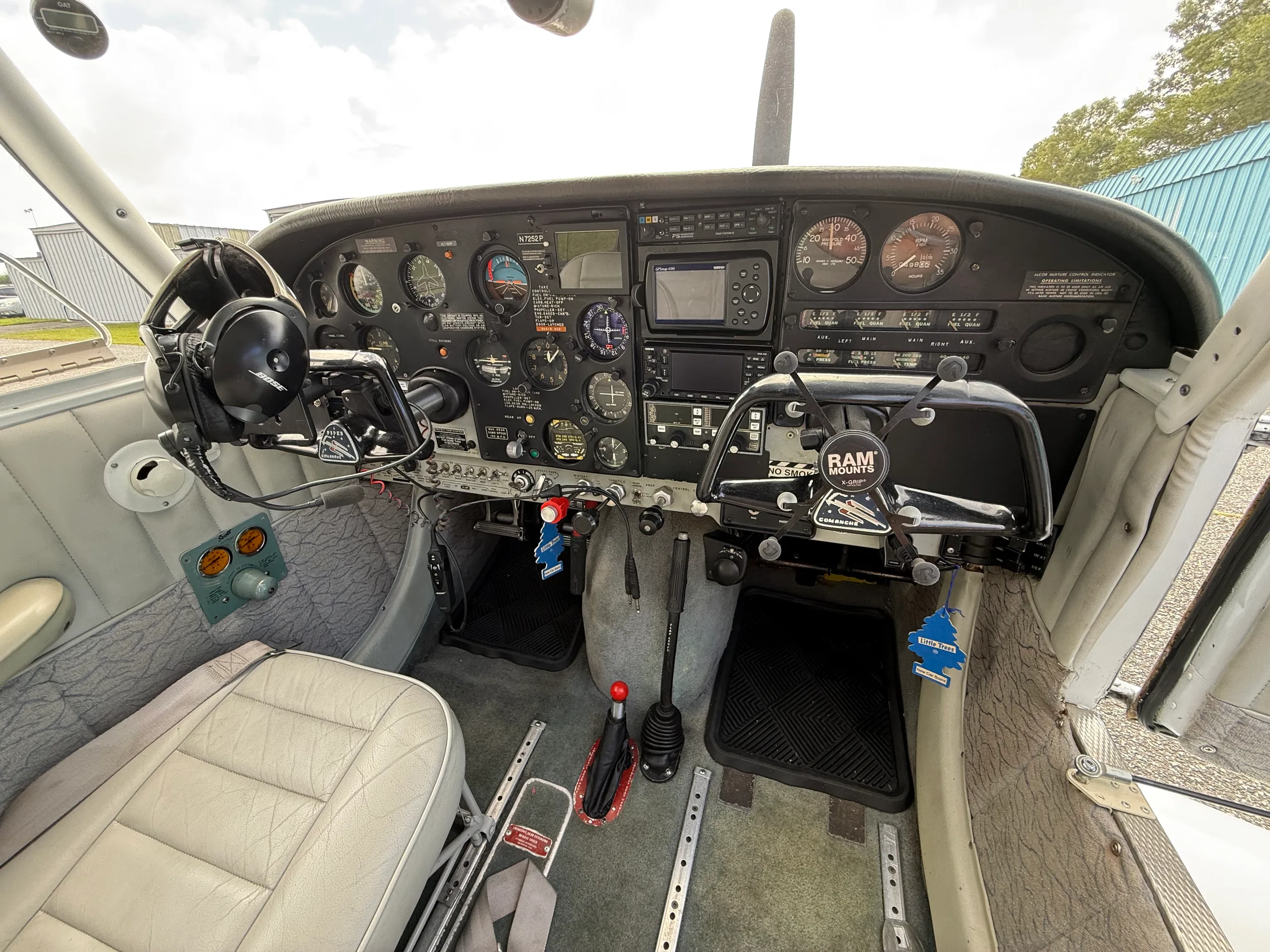 View of the aircraft's instrument panel with various gauges, avionics, and controls, including a yoke with 'RAM MOUNTS' branding.