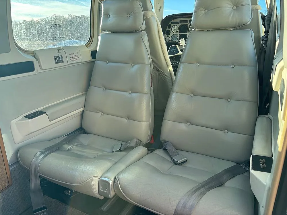 Two light grey leather passenger seats in the aircraft cabin.