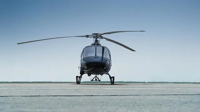 The front view of a dark blue Airbus H125/AS350 helicopter with registration B-7436 parked on an asphalt tarmac.