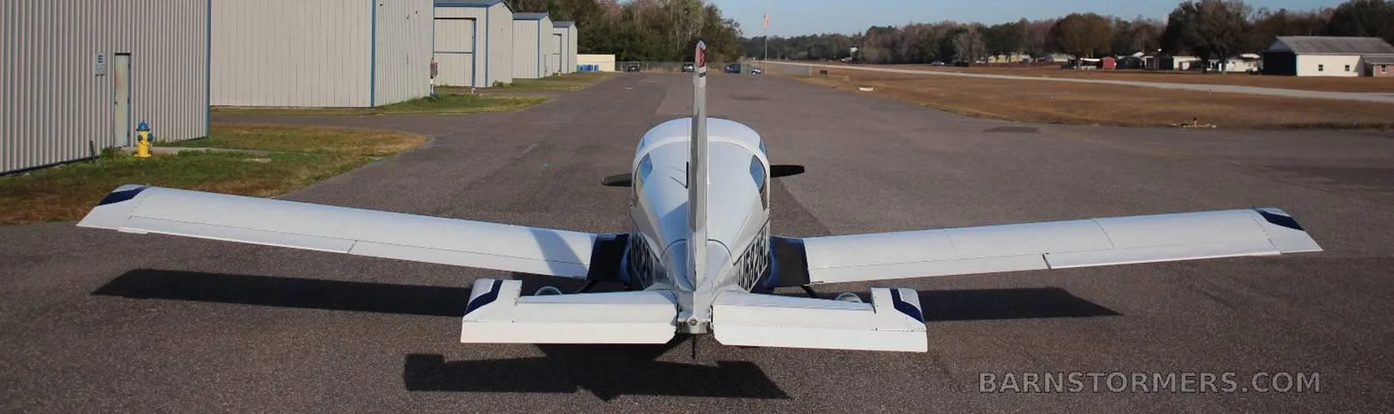 A white and blue Bobcat aircraft (N5826L) parked on an airfield, viewed from directly behind.