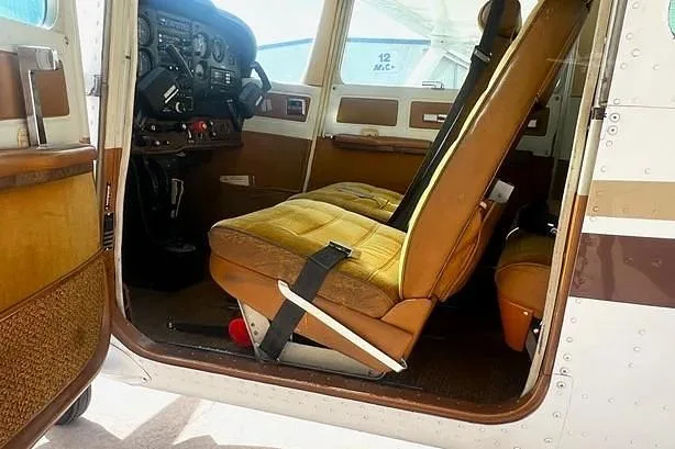 The brown and gold interior of a Cessna Cutlass RG II, showing the front seats and part of the cockpit.