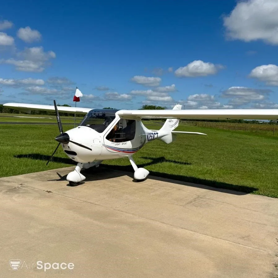 A front-quarter view of a white Flight Design CT Light Sport aircraft, N253CT, parked on a concrete pad.