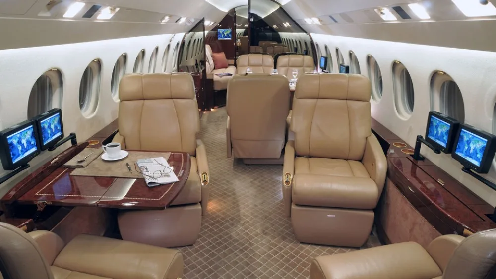 Interior view of the aircraft cabin with leather seats and tables.