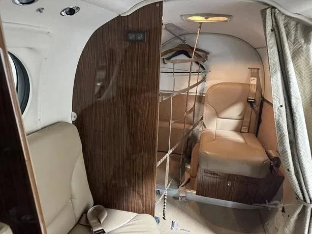 The rear cabin area of a Beechcraft King Air 350i, featuring a lavatory or storage compartment with a curtain.