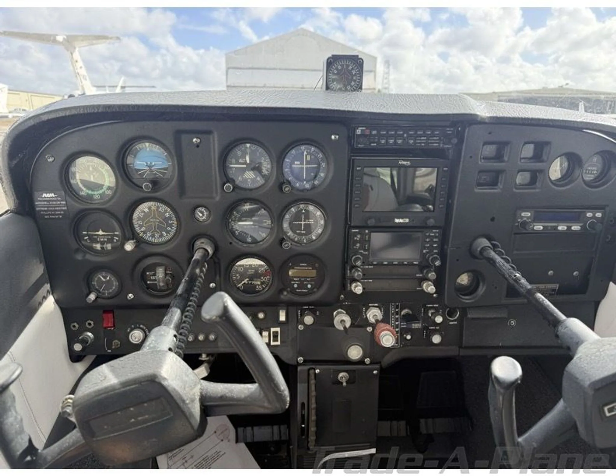 The cockpit of a Cessna 172 with analog gauges and modern avionics.