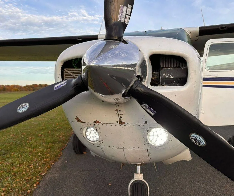 A detailed front view of the aircraft's propeller and nose, highlighting the bright LED landing lights.