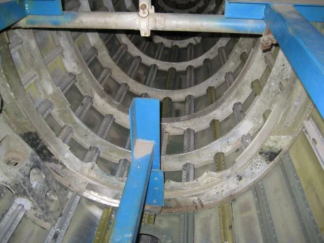 Interior view looking down into a cylindrical aircraft fuselage section, showing structural ribs and stringers.
