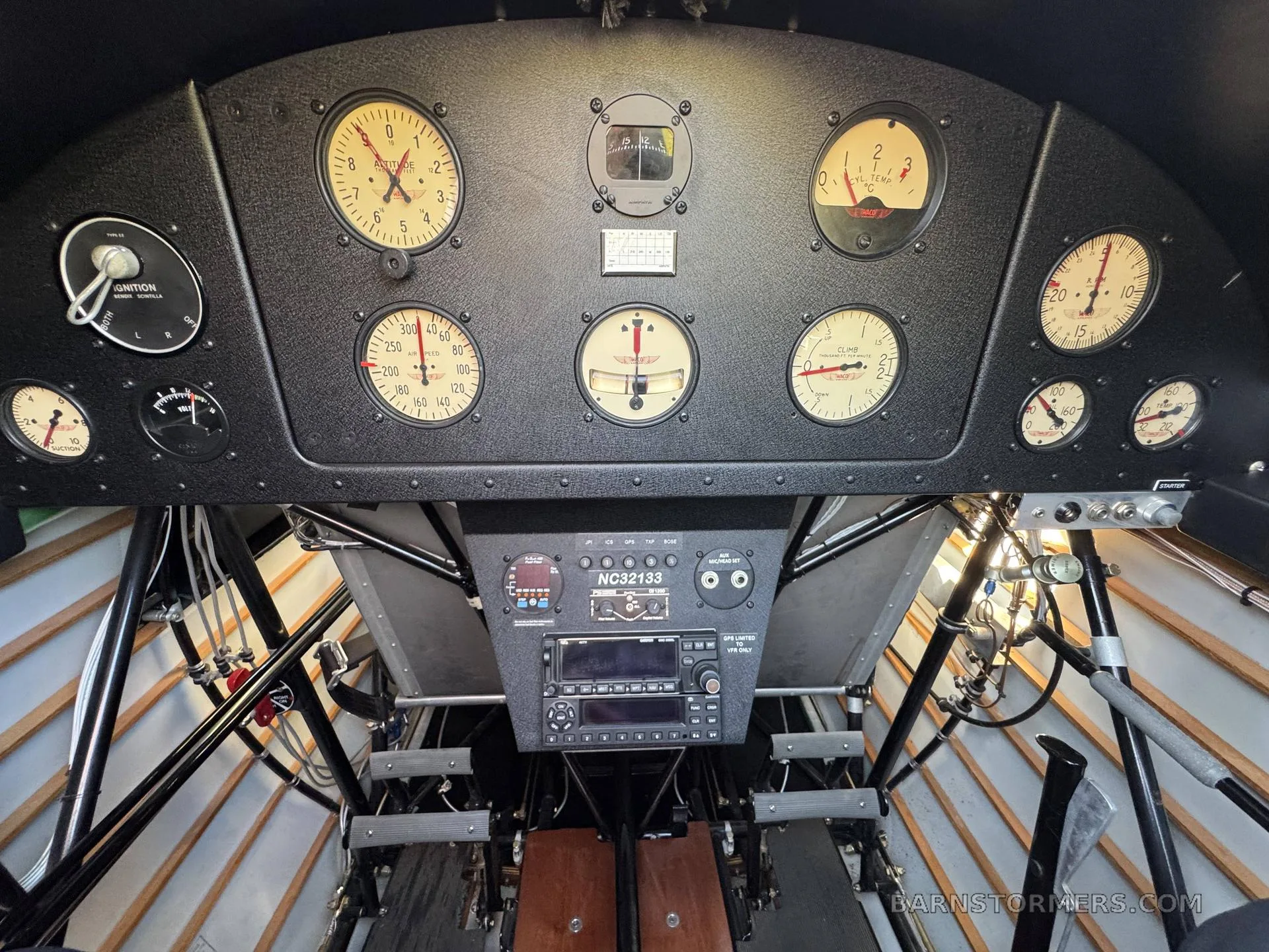 The cockpit instrument panel of an aircraft, featuring analog gauges and a modern radio stack with registration NC32133.