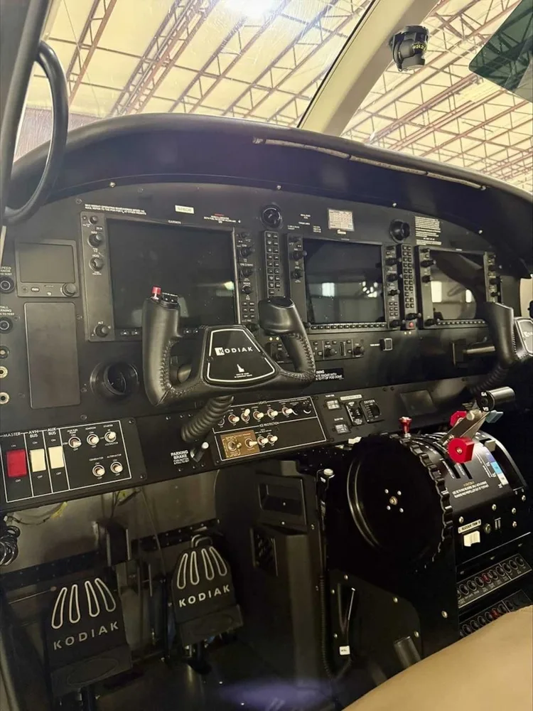 The cockpit of a Kodiak aircraft, showing the instrument panel with multiple screens and controls.