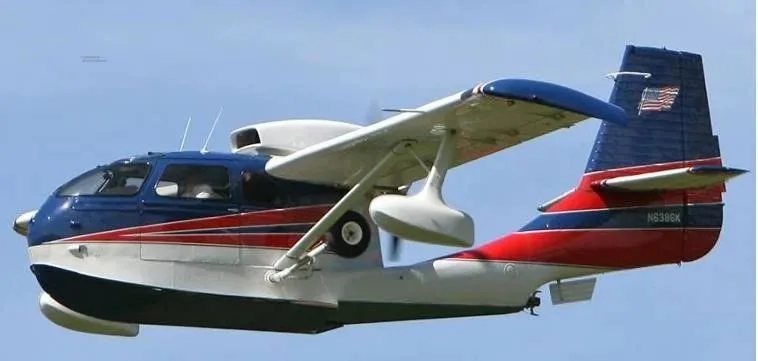 A blue, white, and red amphibious aircraft with registration N6386K flying in a clear sky.