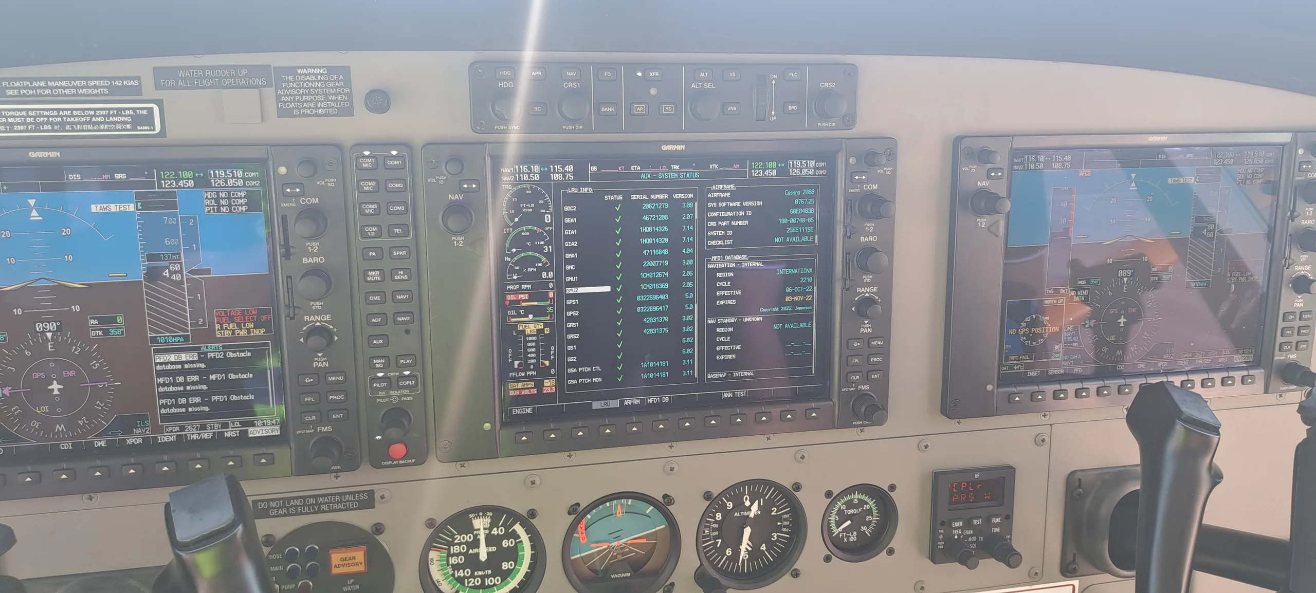 The cockpit instrument panel of an aircraft displays multiple digital screens and analog gauges.