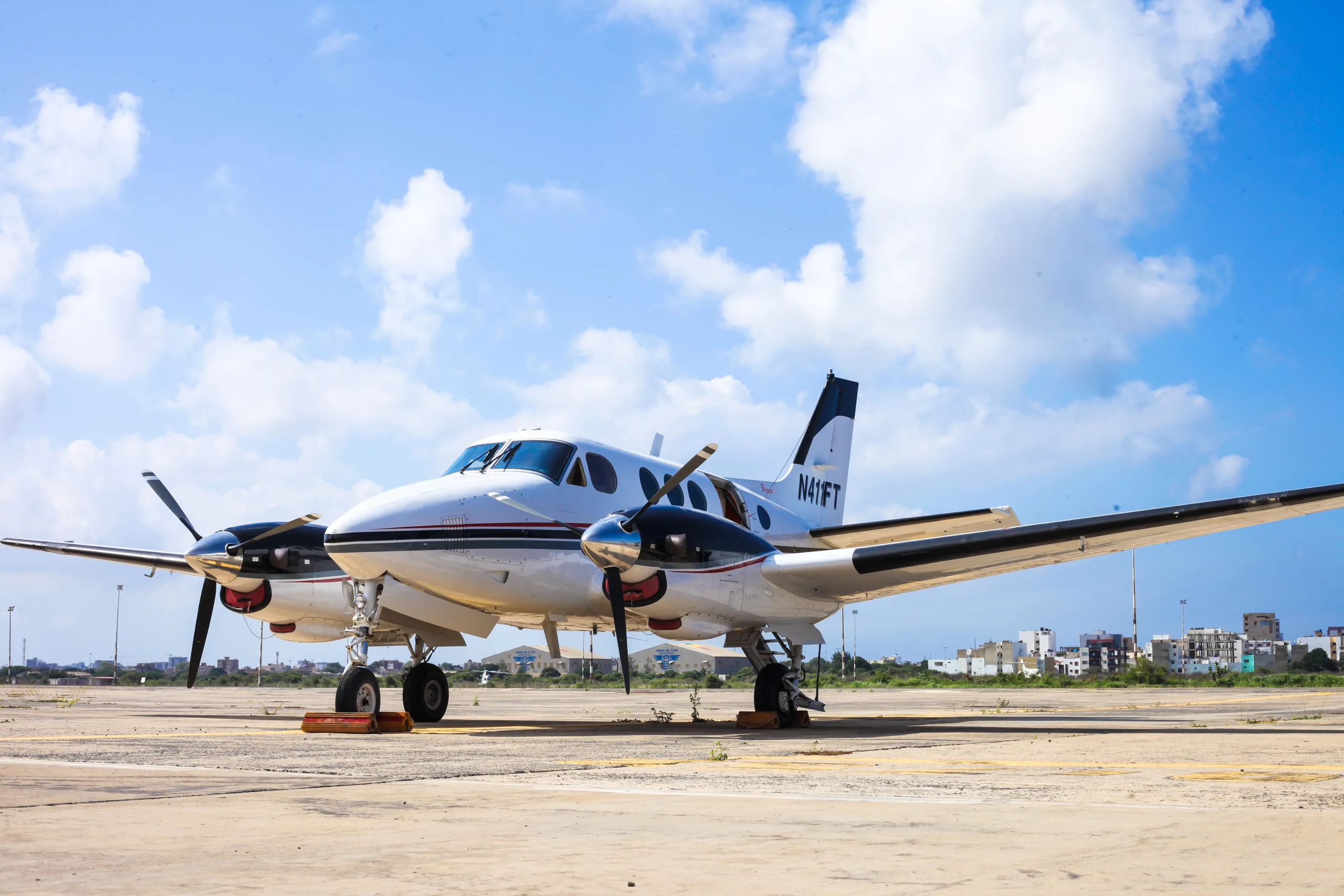 A King Air N411FT is parked on the tarmac with chocks in place.