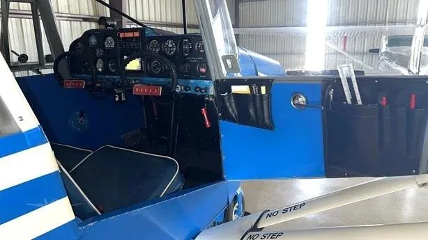View of the aircraft's cockpit with the instrument panel and front seats visible.