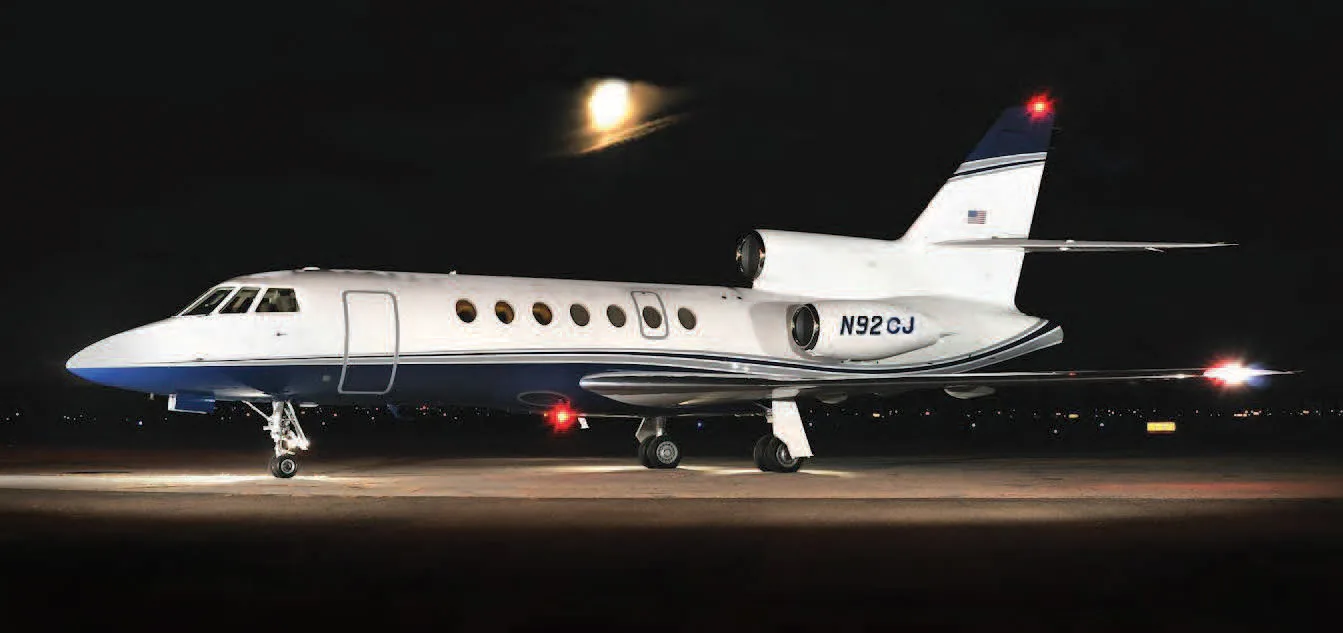 Side view of the aircraft N92CJ on the tarmac at night.