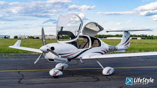 A white Diamond DA40 aircraft with red and black stripes, registration N301MJ, parked on an airfield with its canopy and doors open.