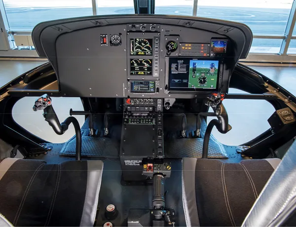 Helicopter cockpit with modern avionics and controls.