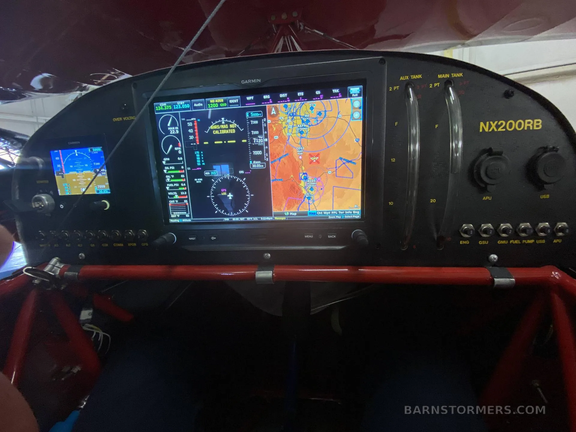 The cockpit instrument panel of an aircraft, featuring multiple Garmin displays showing flight data and a map.