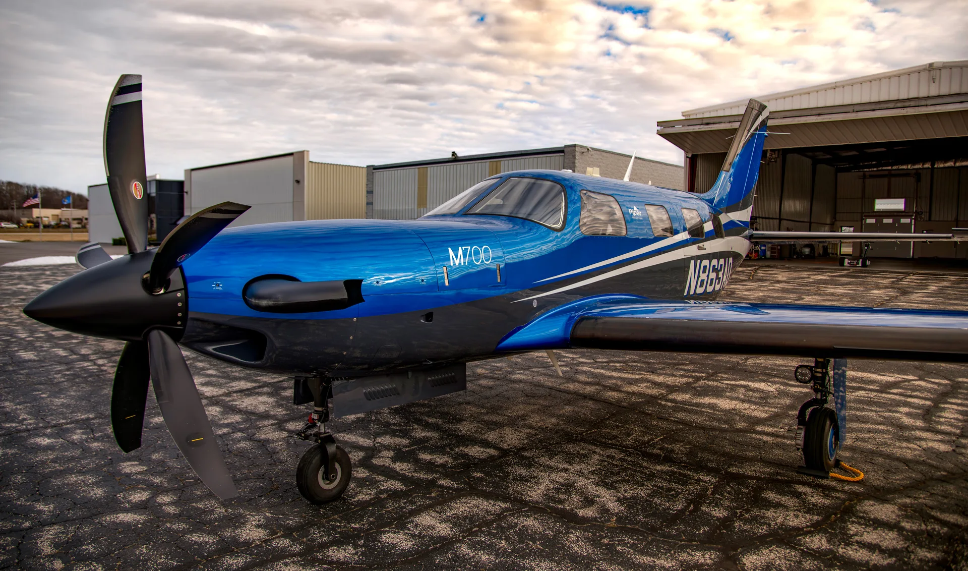 A close-up of the blue and black M700 aircraft on the tarmac.