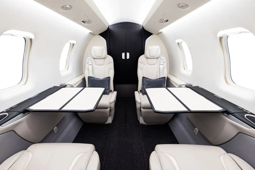 View of the aircraft's interior cabin with white leather seats.