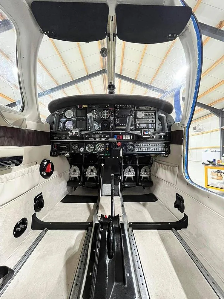 A wide-angle view of the aircraft's cockpit, showing the instrument panel, controls, and pedals.
