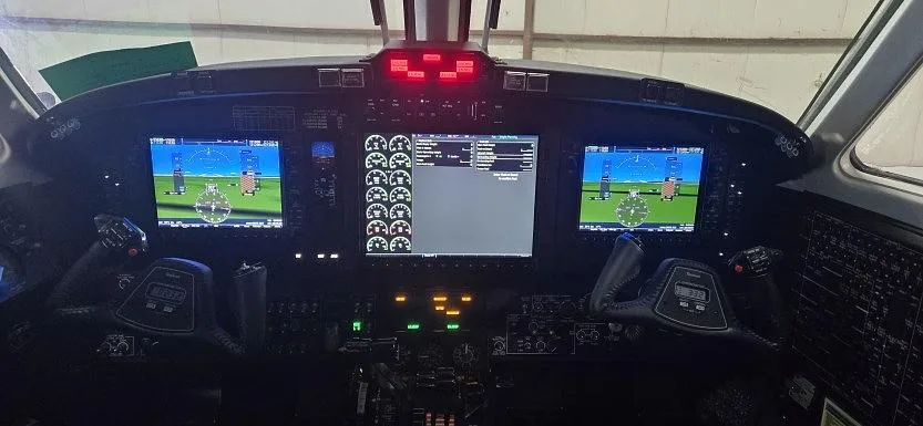 The cockpit of an aircraft featuring a modern glass panel with multiple digital displays and controls.