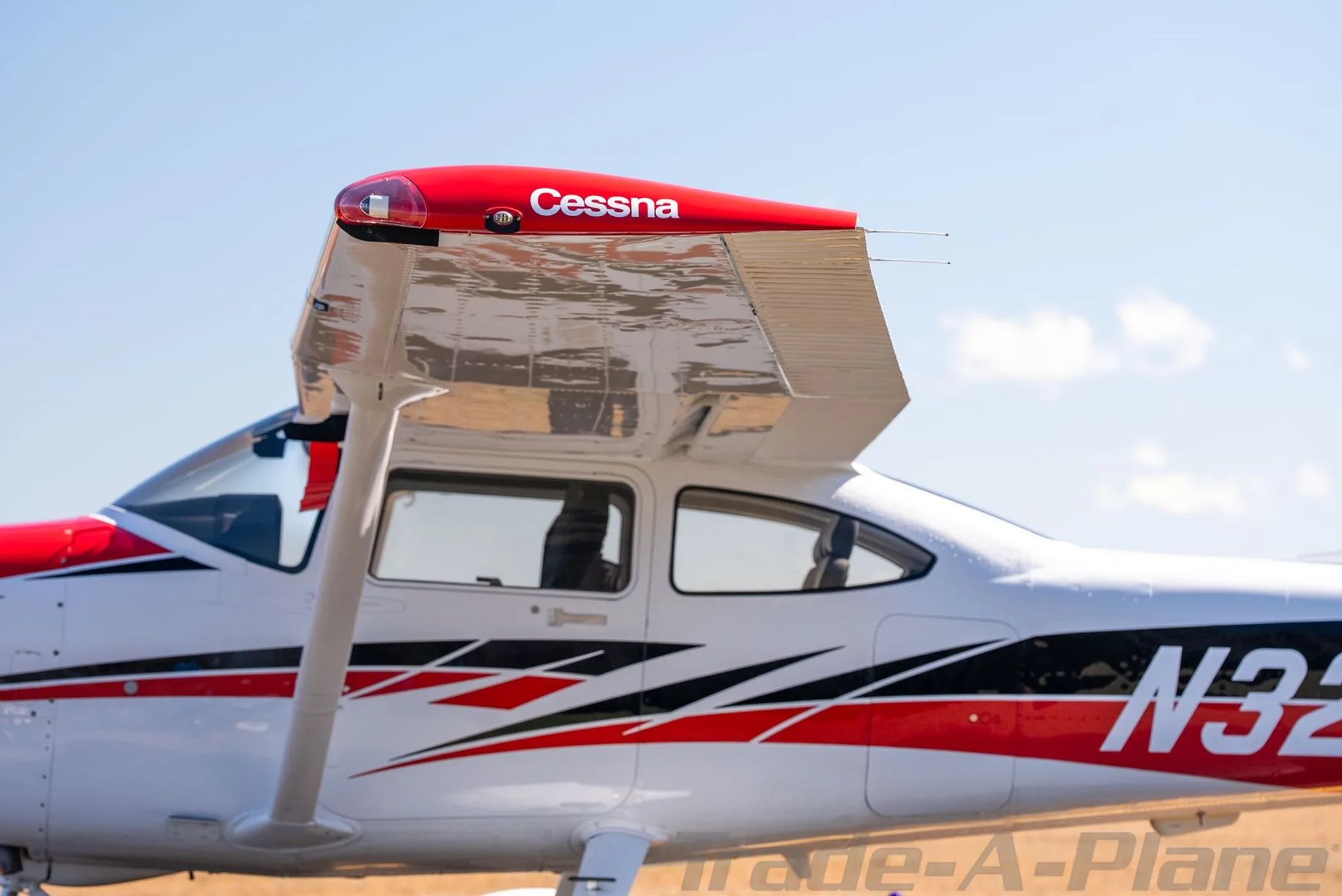 A close-up view of the right wing and fuselage of Cessna Skylane N32LP, showing the "Cessna" logo on the wingtip.