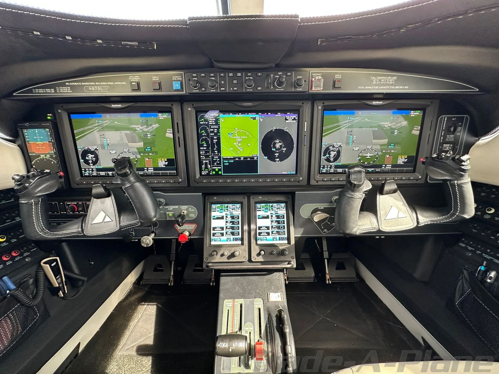 A close-up view of the Piper M600/SLS cockpit, showing the three large Garmin G3000 primary flight displays and center console.