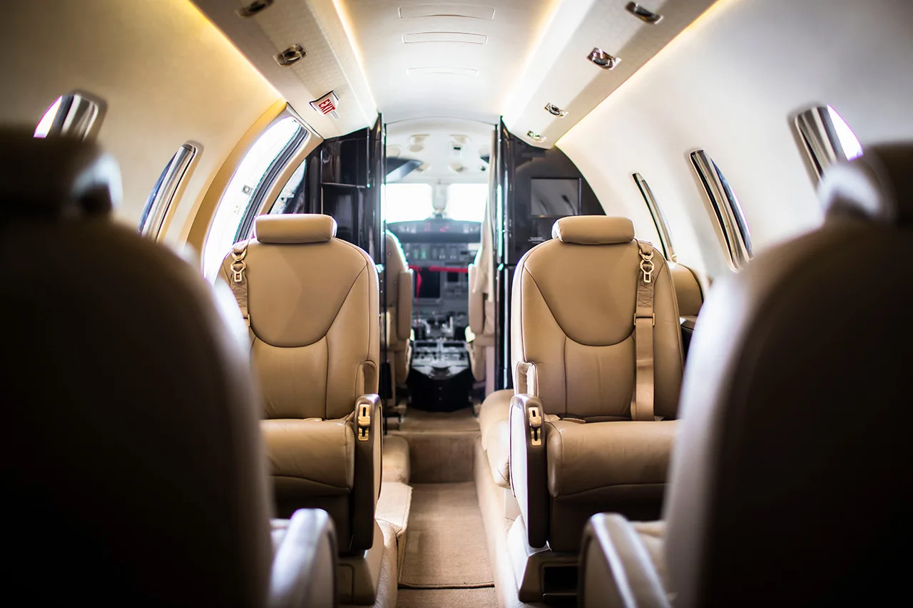 The interior of a Cessna Citation CJ3 aircraft, showing the cabin seats and cockpit.