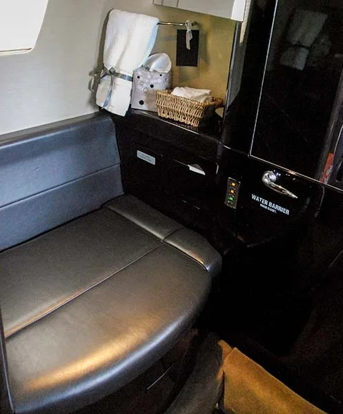 Aircraft lavatory with seat and amenities.
