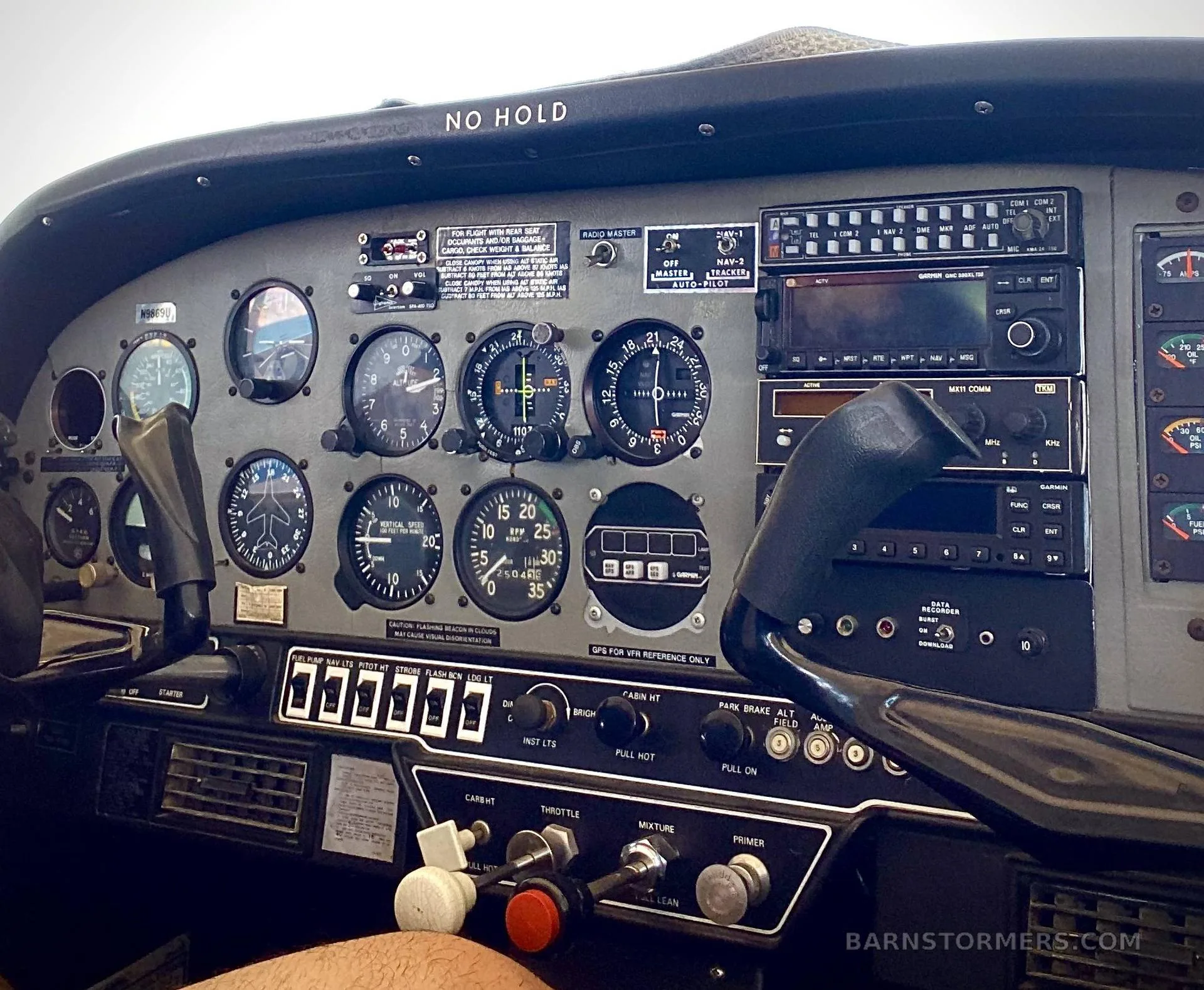 A detailed view of the aircraft's instrument panel, showing various gauges, radios, and flight controls.