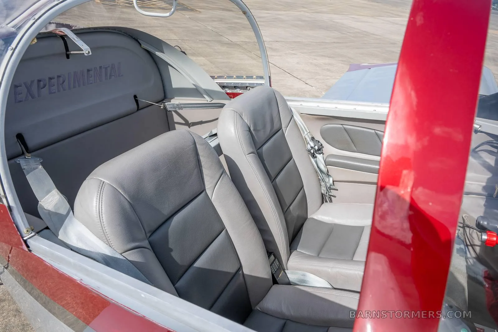 The gray leather seats and interior cabin of the experimental aircraft, with "EXPERIMENTAL" visible on the rear bulkhead.