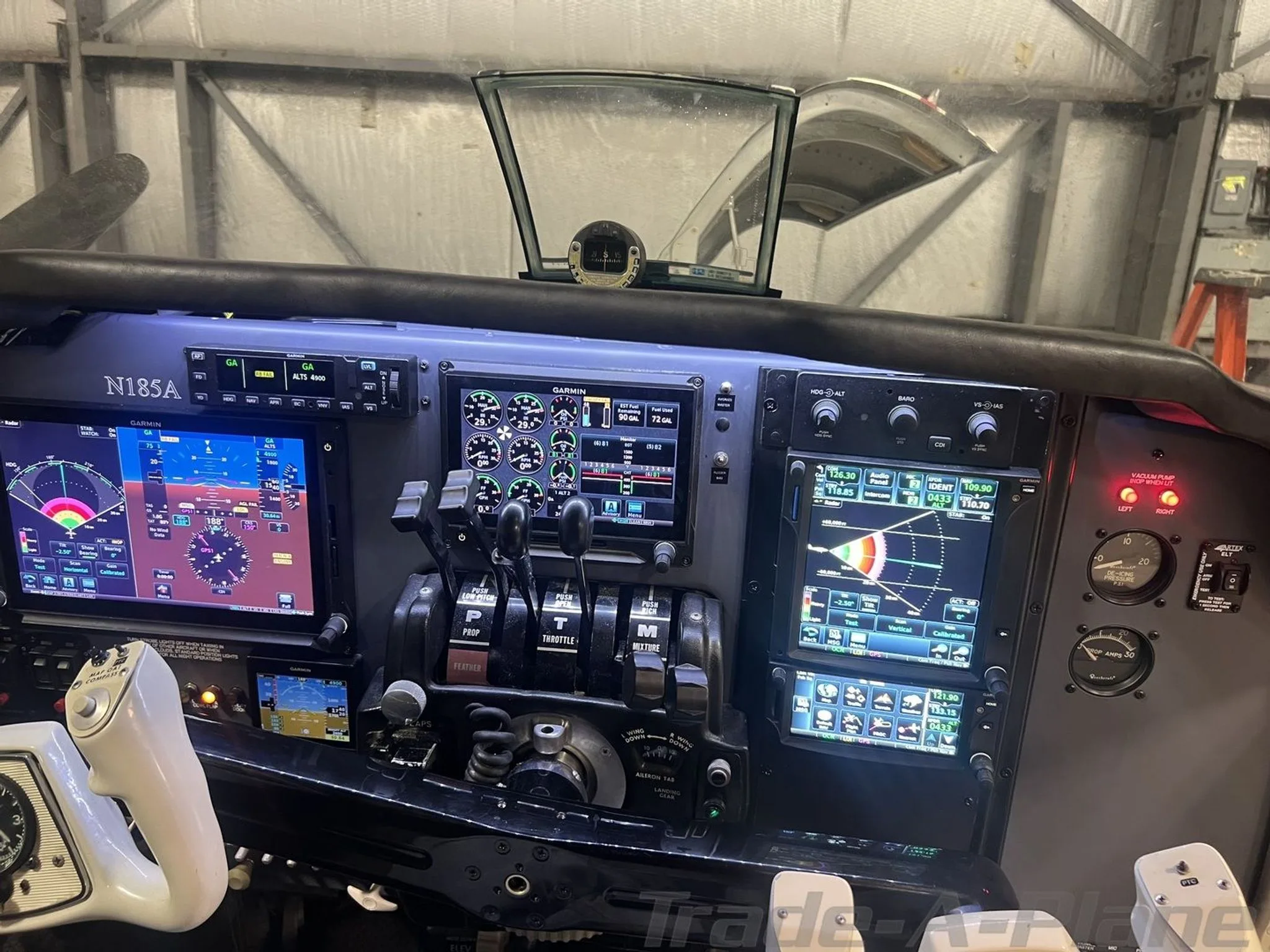 A detailed view of the modern glass cockpit with multiple screens and controls of the N185A aircraft.