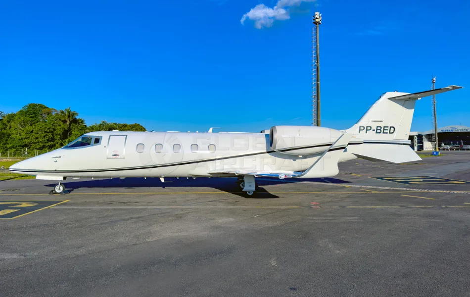 A white business jet with registration PP-BED is parked on an airport tarmac under a clear blue sky.